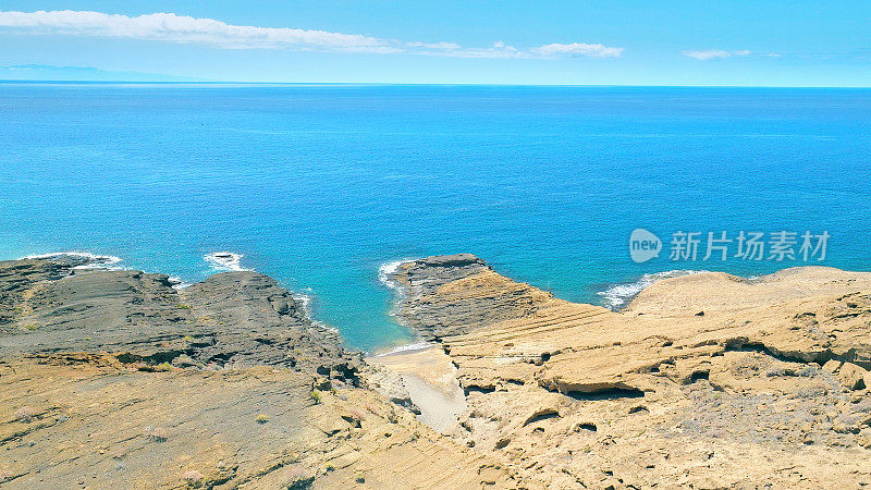 Aerial view of the hidden cove beach "Playa Cumplida" at the natural reserve of "Montaña Pelada" in Tenerife (Canary Islands). Drone shot